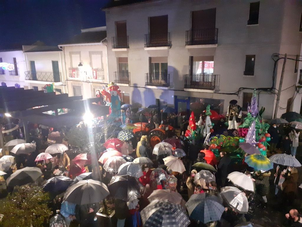 Cabalgata Miguel Esteban carrozas en plaza y gente con paraguas